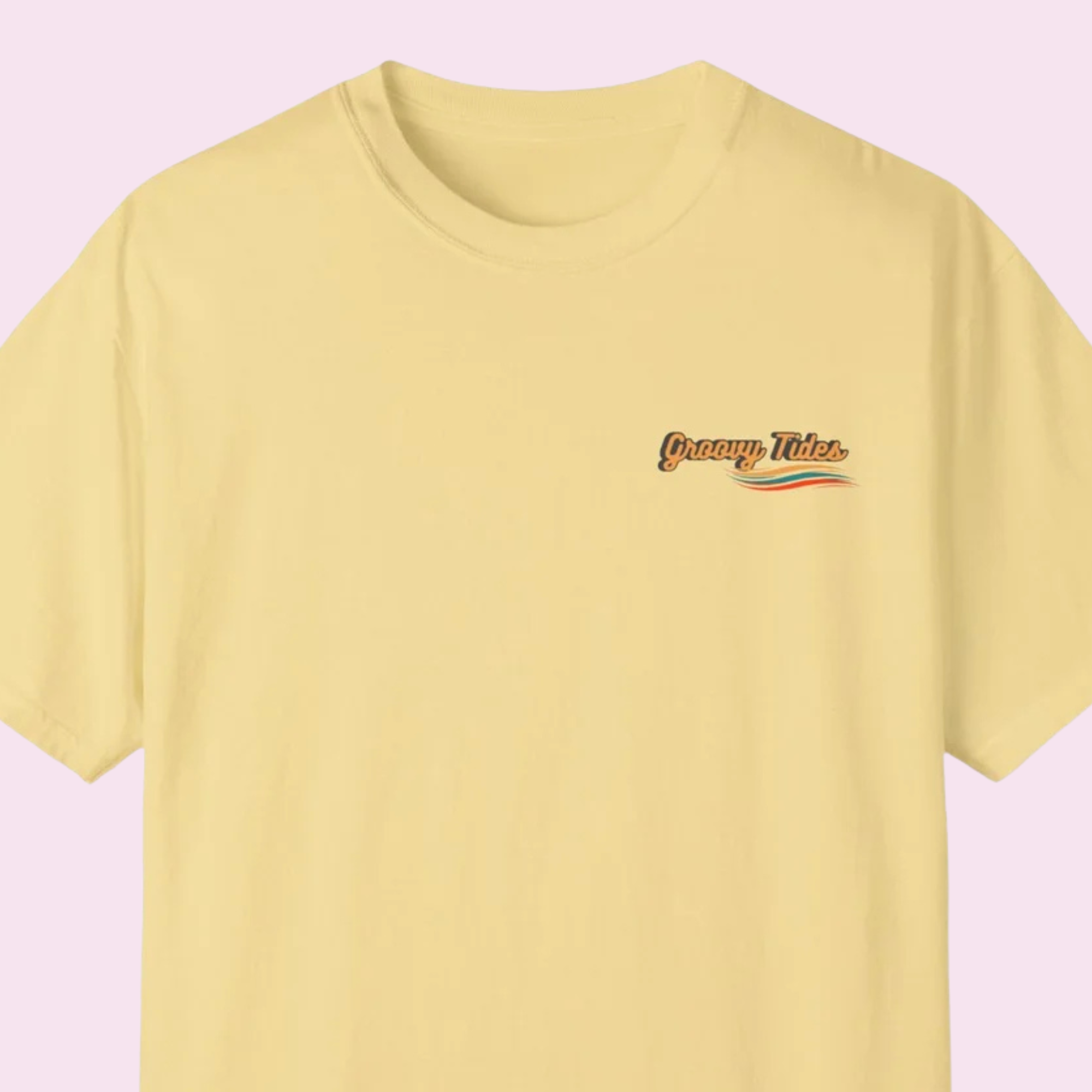 Front chest logo detail — Groovy Tides script lettering with wave graphic in teal, orange, and red on a butter yellow t-shirt